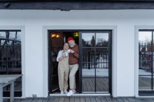 Senior couple downsizing after 60 stands outside a smaller one-story home