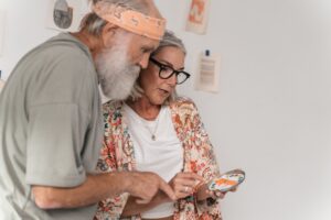 Older couple reviewing tile samples at their kitchen table while planning aging in place renovations