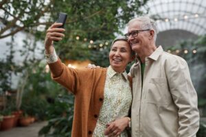 Two people over 60 laughing together taking a selfie on a date
