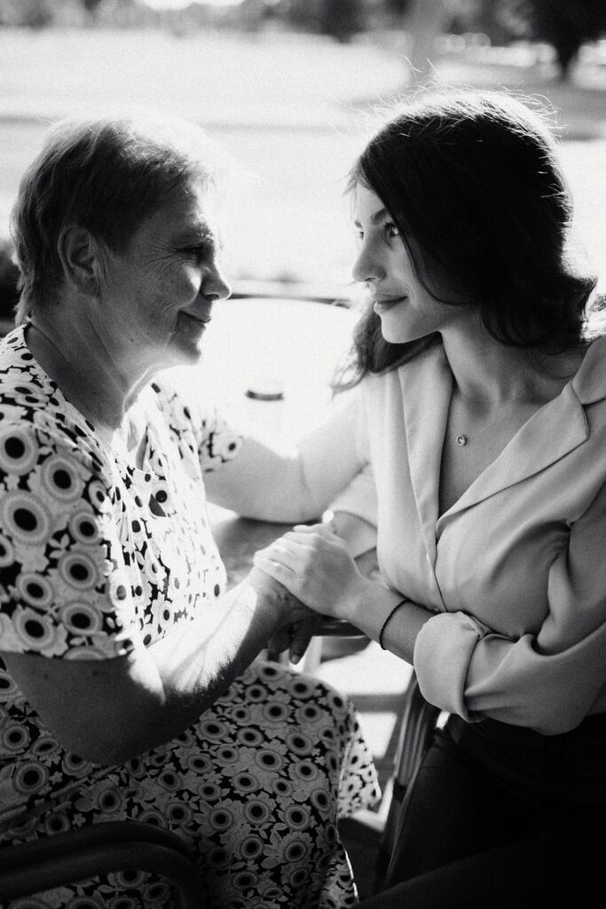 Adult daughter and her mother talking on a couch about how to spot and report scams