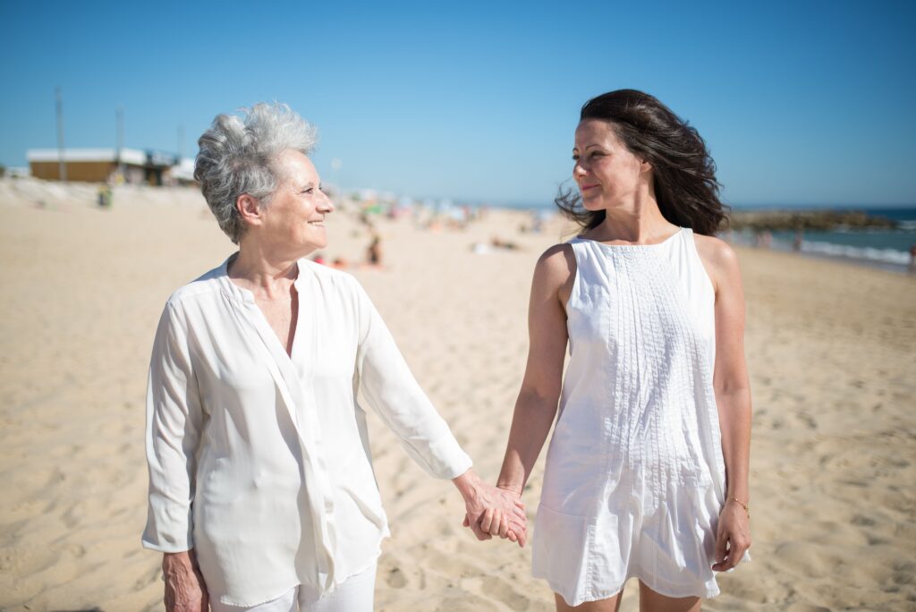 Senior Mom and her Adult daughter walking hand in hand