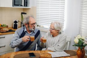 Woman in her 60s with coffee in a sunny kitchen, adjusting after she retired earlier than planned